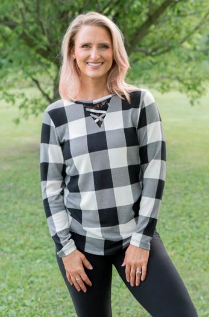 lady with black and white plaid shirt. Shirt has a black V shape with white lacein the center front.